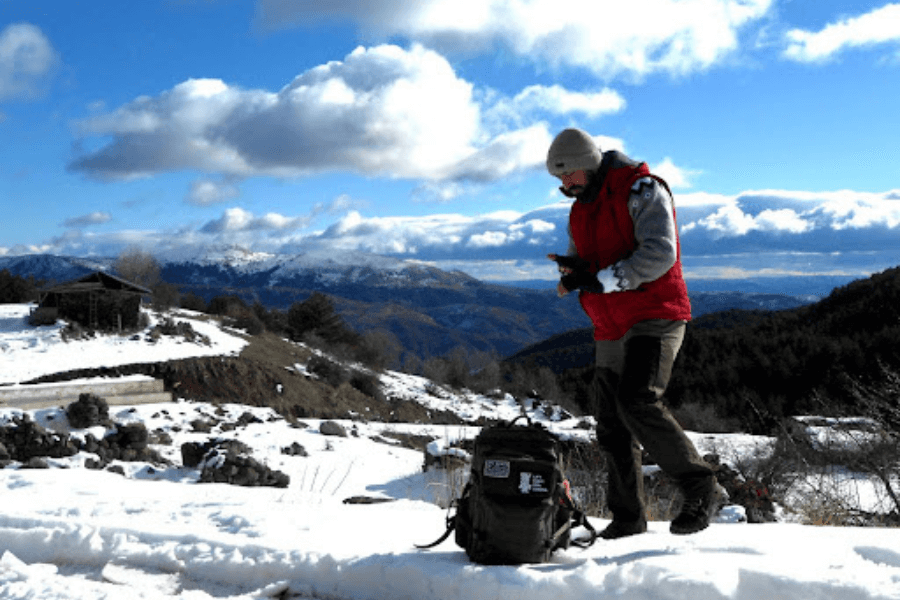 A man, outdoor in winter, mountains, backpack.