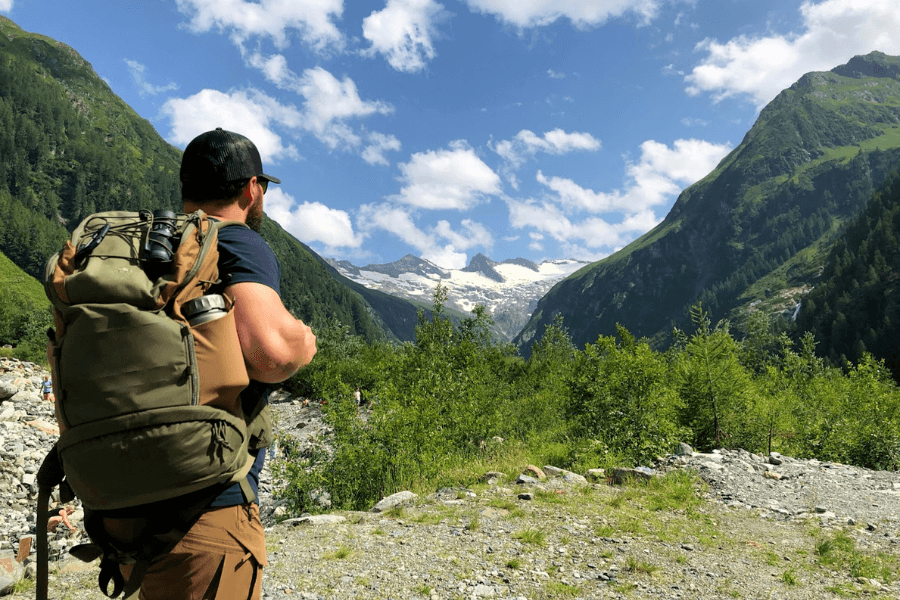 A man with a backpack and a thermos in the mountains